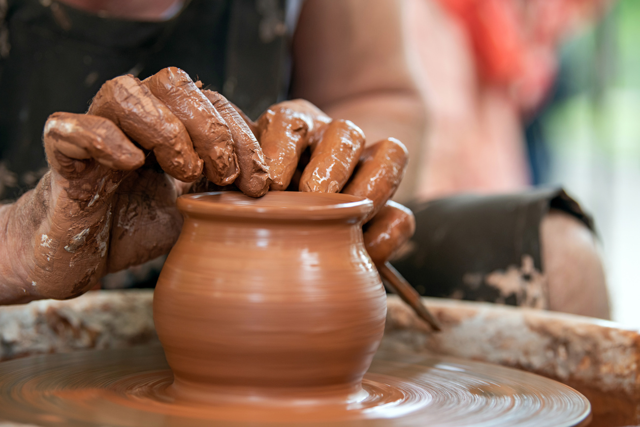 Potter makes pottery dishes on potter's wheel